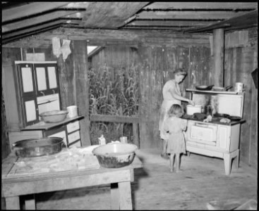 Mrs. Monroe Jones in the kitchen of the four room house which serves as the family's home and for which they pay... - NARA - 541190