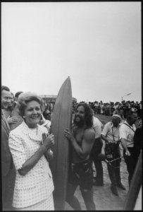Mrs. Nixon at the beach standing next to a surfer - NARA - 194733