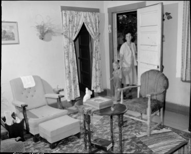 Mrs. Paul May, wife of miner, and her young son enter their front door of their four room house for which they pay... - NARA - 540977