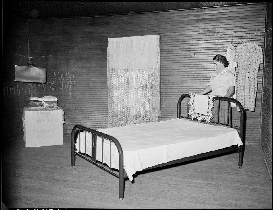 Mrs. Oscar Powers, wife of a miner, in the bedroom of their three room house, they get a reduced rental rate of $4.50... - NARA - 541165