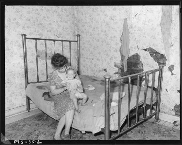Mrs. Ray Ruiexline, mother of 6 children, with 13 months old baby in bedroom of home. Christopher Coal Company... - NARA - 540231