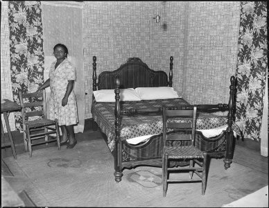 Mrs. Robert Harold in the bedroom of her house. Her husband, a miner, has lived in this house for sixteen years. For... - NARA - 541054