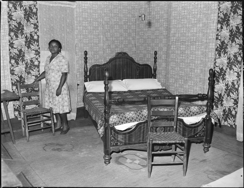 Mrs. Robert Harold in the bedroom of her house. Her husband, a miner, has lived in this house for sixteen years. For... - NARA - 541054