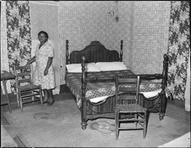 Mrs. Robert Harold in the bedroom of her house. Her husband, a miner, has lived in this house for sixteen years. For... - NARA - 541054 photo