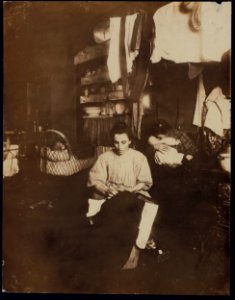 Mrs. Tony Racioppo, 260 Elizabeth St., N.Y. 1st floor rear, finishing pants in dirty tenement home. Althou(gh) it is a licensed house, the whole place is very much run down. The ahllway LOC nclc.04151 photo