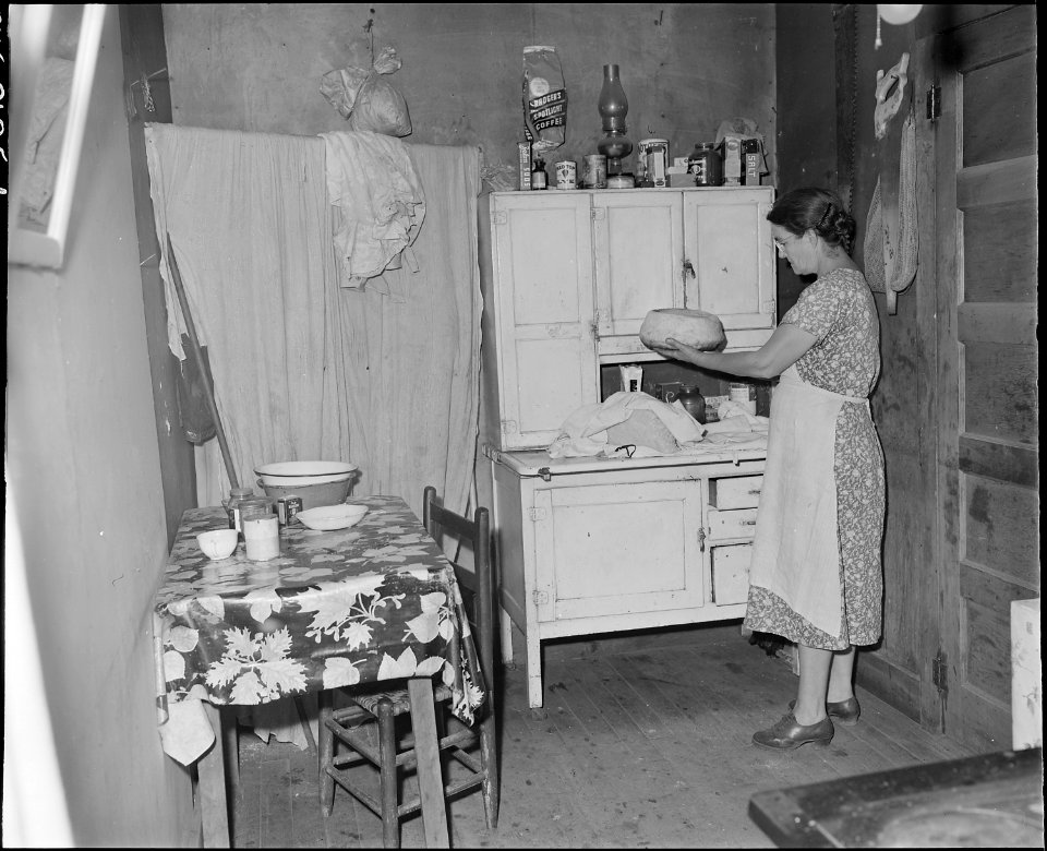 Mrs. Tudor Circo in the kitchen of the two room house for which she and her husband pay $3.50 monthly. Raven Red Ash... - NARA - 541109
