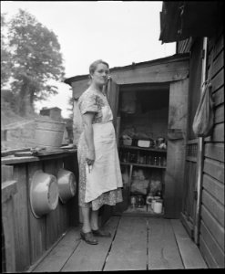 Mrs. Tudor Circo on the backporch of the house for which she and her husband pay $3.50 monthly. It has two rooms, her... - NARA - 541108