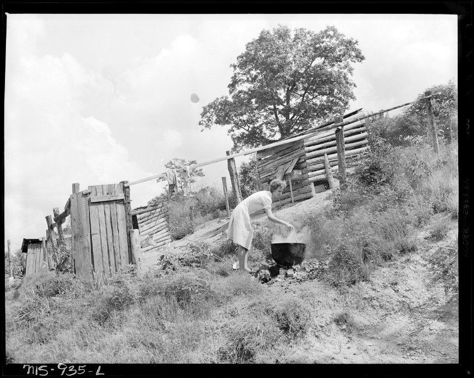 Mrs. William McMillan, wife of miner, stirring the laundry in open kettle in her backyard. Brilliant Coal Company... - NARA - 540615