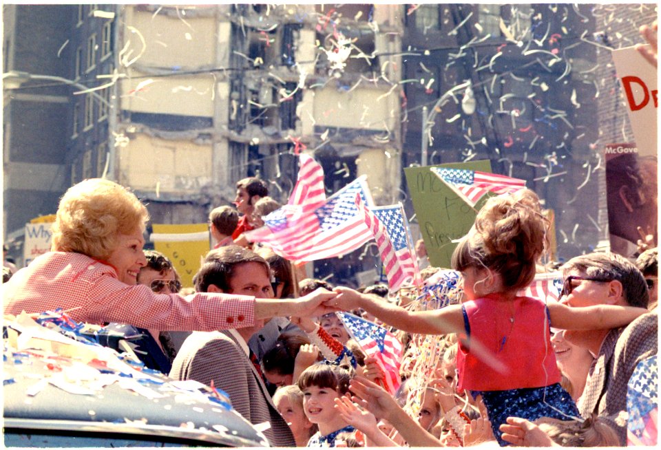 Mrs.Nixon reaching out to a little girl from her car in a campaign motorcade in Atlanta, Georgia. - NARA - 194455