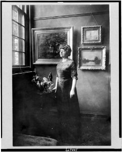Mrs. Woodrow Wilson (Ellen Louise Axson), full-length portrait, standing by window in room with paintings, facing left LCCN90710063