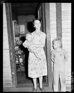 Mrs. Walter Rose, wife of miner, with her two children in doorway of their three room house - NARA - 540757 photo
