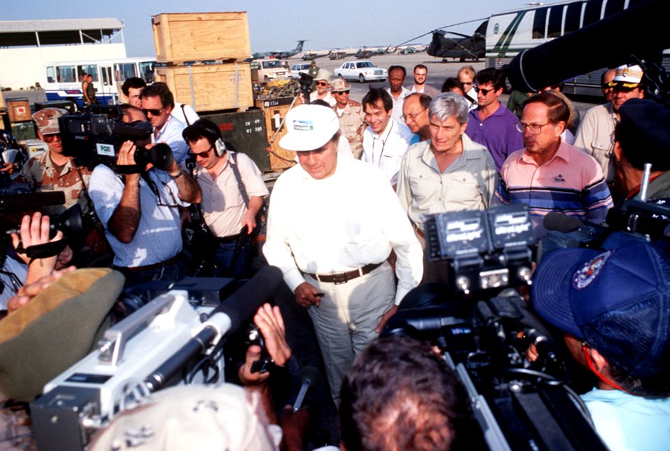 Media personnel crowd around Robert Dole, John Warner, and Sam Nunn