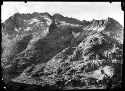Muntanyes de la vall de Tena amb clapes de neu i a baix part d'un llac