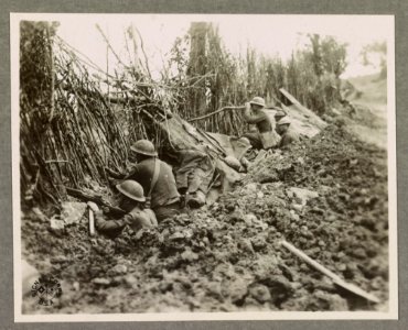 Members of the 132nd Inf., 33rd Div., in front line trench taking advantage of the camouflage left by the Germans The German line is about 1200 yds. from this point the Meuse being between. LCCN2016651605