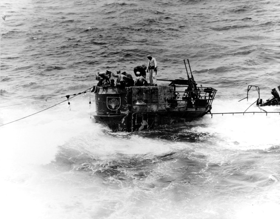 Members of the U.S. Navy salvage party use a small handy-billy pump to dewater the partially scuttled German submarine U-505 on 4 June 1944 (80-G-49167)