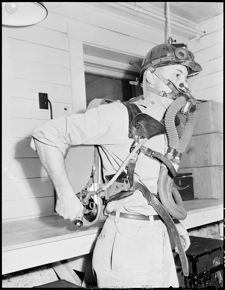 Member of mine rescue team of safety department adjusts oxygen-breathing equipment for use in gaseous mine explosion... - NARA - 541454
