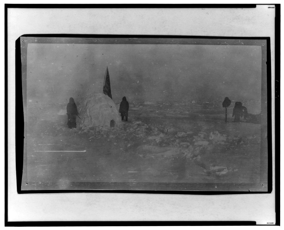 Members of Frederick Cook's journey expedition at the North Pole, with U.S. flag stuck in igloo, at camp site LCCN2001695567