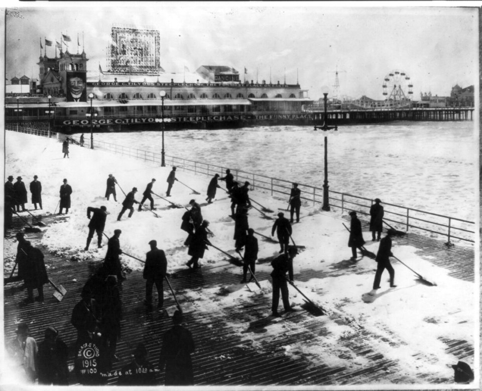 Men clearing snow off boardwalk, Atlantic City, N.J., on Easter Sunday; Steeplechase Pier in backgrd. LCCN2003690285