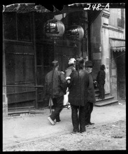 Men standing or walking down a sidewalk, Chinatown, San Francisco LOC agc.7a09026