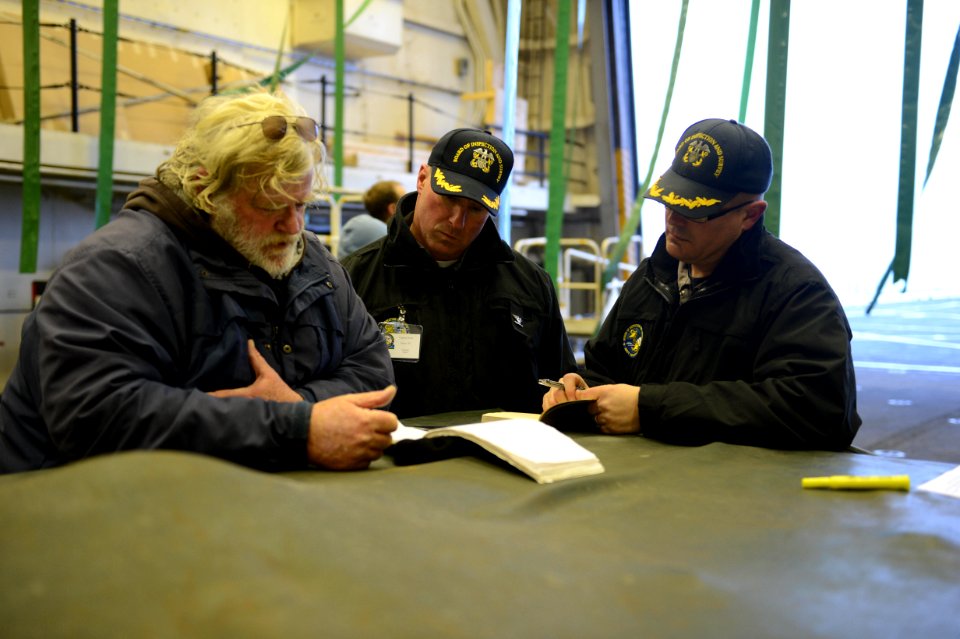 Members of a U.S. Navy Board of Inspection and Survey (INSURV) discuss the next scheduled equipment demonstration aboard the amphibious transport dock ship USS Mesa Verde (LPD 19) Jan. 16, 2014, in the Atlantic 140116-N-BD629-018