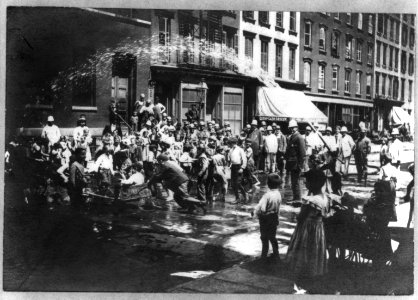 N.Y.C. children in hot weather, playing under spray of fire hydrant, policemen standing by LCCN2016648955