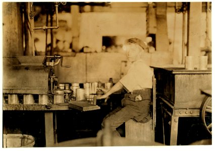 Name- Dangerous Business. Boy working at canning machine with open gearing. Many suck machines and boys too. J. S. Farrand Packing Co. Witness-J. W. Magruder. July 7, 1909. LOC nclc.00751