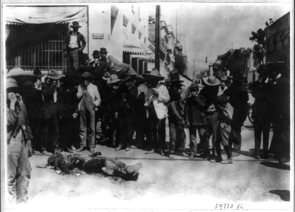 Mexico City - Feb. 1913- group of civilians holding their noses beside charred corpse LCCN2006685904