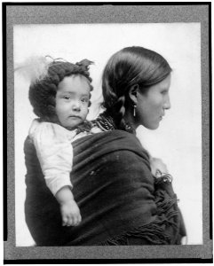 Native American woman from Plains region, half-length portrait, facing right, with baby on her back) - Beach, N.Y LCCN96501569 photo