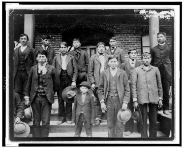 Native American men and a boy posed outside of Carlisle Indian School LCCN99471846