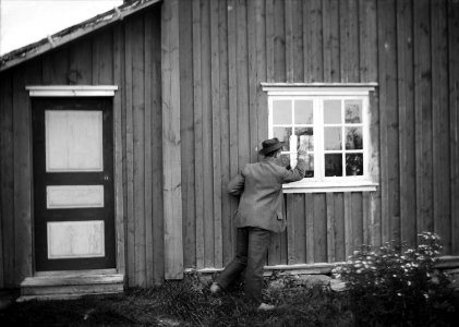 Nattfrieri. En man knackar på fönstret till stuga. Värmland, Mangskogs sn - Nordiska museet - NMA.0027983