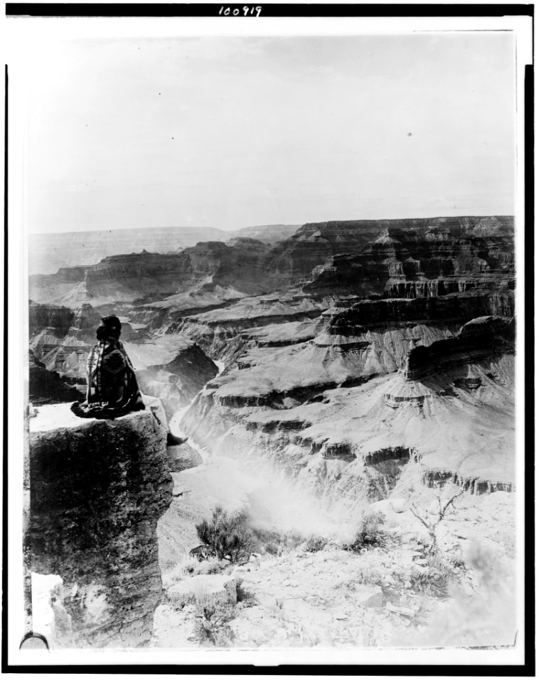Native American seated on the edge of the Grand Canyon, Arizona LCCN90715600