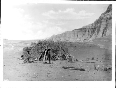 Navajo family at their hogan in Blue Canyon, showing a horse near the entrance, ca.1900 (CHS-4734)