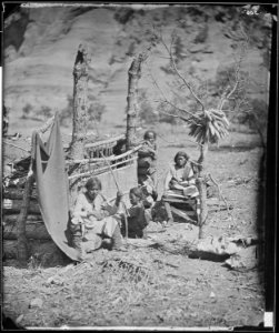 Navajo family group in Canyon de Chelle, New Mexico Territory, woman weaving at loom, man holding bow and arrow - NARA - 524256