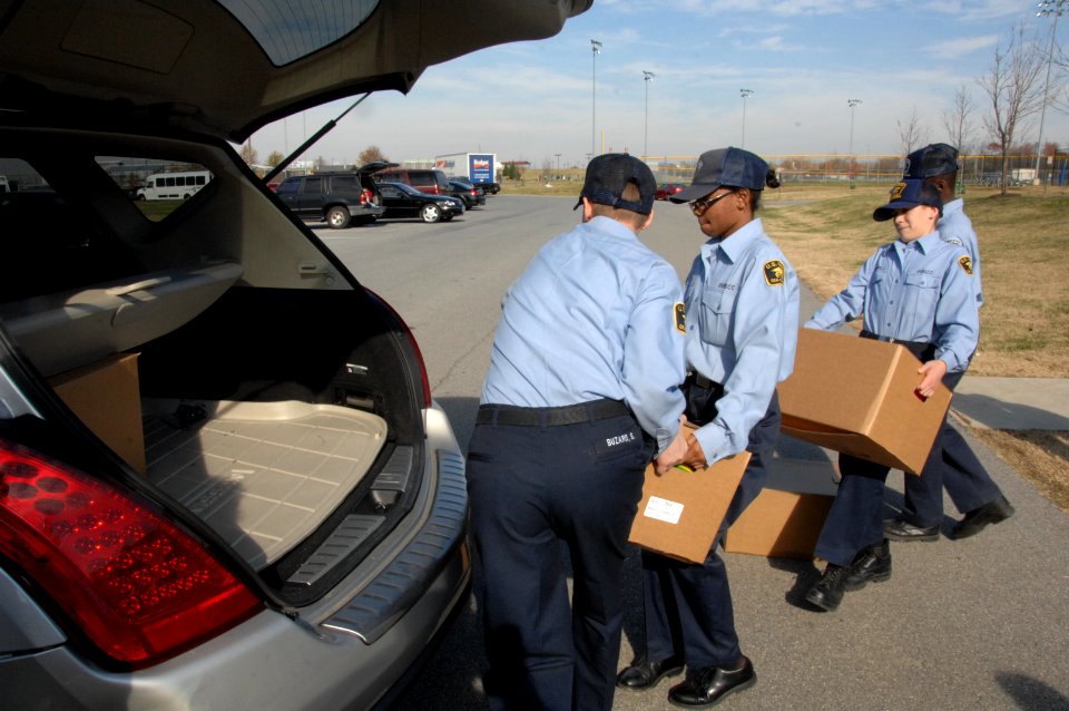 Naval Sea Cadets Kendall Kent and Keith Buzard, left to right, pass boxes of food