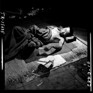 Navy photographer pictures suffering and ruins that resulted from atom bomb blast in Hiroshima, Japan. Victim lies in... - NARA - 520933