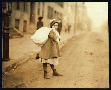 Nearly 9 A.M. Girl (about 8 yrs. old) carrying sack of hose supporters home, a long distance and she had to run to get home in time for school. Up hill and tiring work, resting frequently. LOC nclc.04296