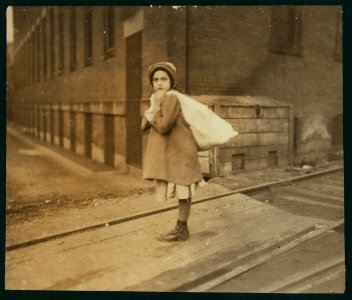 Nearly 9 A.M. Girl (about 8 years old) carrying sack of hose supporters home, a long distance and she had to run to get home in time for school. Up hill and tiring work, resting frequently. LOC nclc.04295