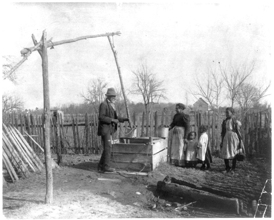 Negro man, woman and three children at an old-time well LCCN2001703806
