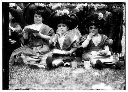 Midgets eating lunch - May party - Central Park. Three midgets sitting on the grass. LCCN2014688122