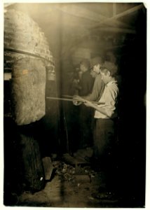 Midnight in a Glass Works in Grafton, W. Va. Boys at the 'Glory-Hole' where object is reheated before going to finisher. LOC nclc.05363