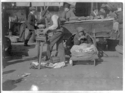 New York City street peddler; man sharpening saws and woman selling peanuts, Hester and Norfolk Streets LCCN2016648985