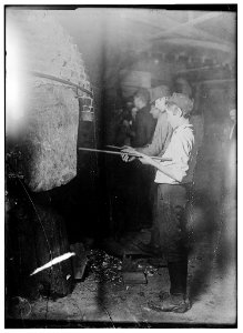 Midnight in a Glass Works in Grafton, W. Va. Boys at the 'Glory-Hole' where object is reheated before going to finisher. LOC nclc.05363