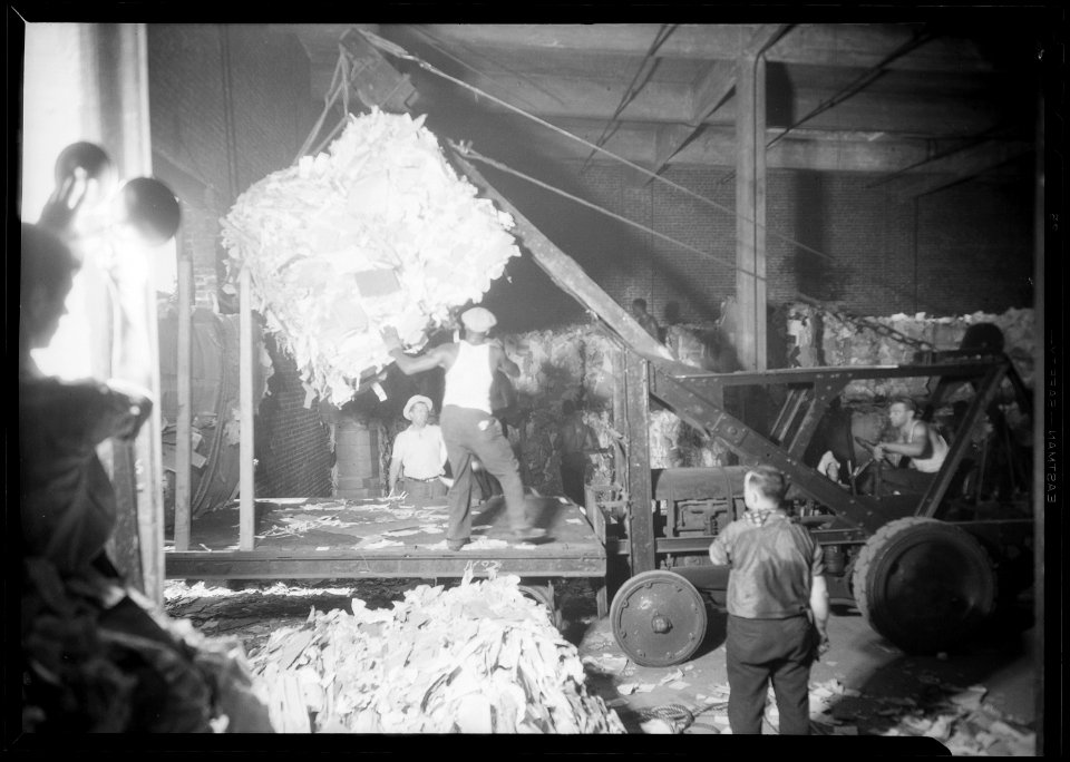 New York, New York - Longshoremen. Large bale being lifted by crane and directed by man on platform. - NARA - 518788