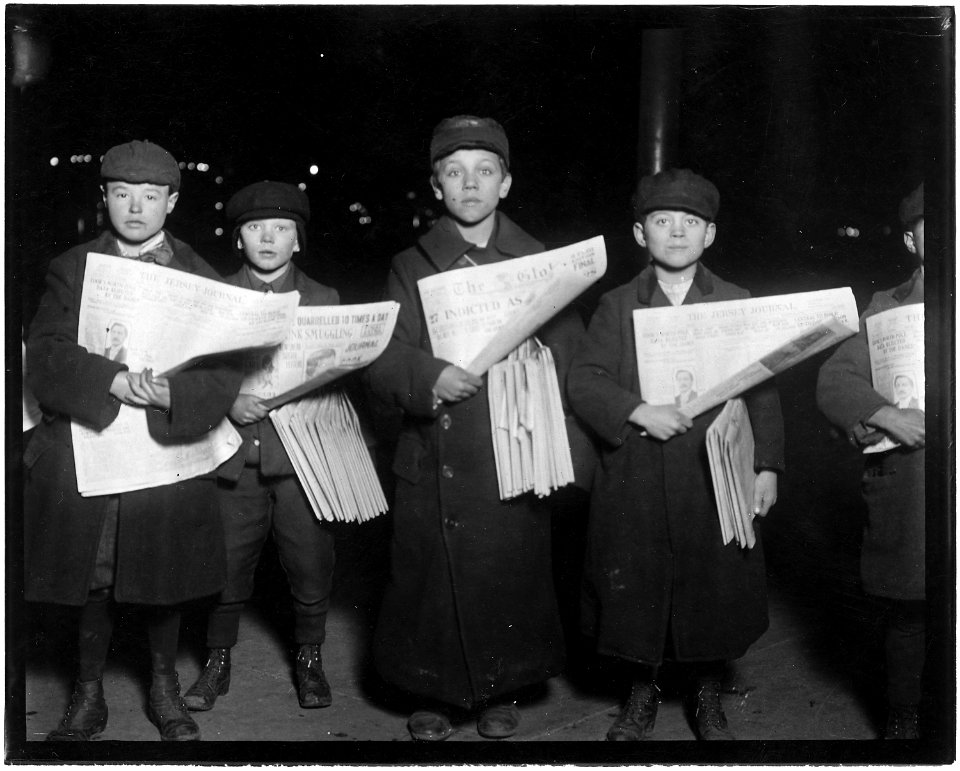 Newsie selling at the Hudson Tunnell Station, Jersey City. Boy on left is Patrick Drohan, 12 years old. Next to him... - NARA - 523245
