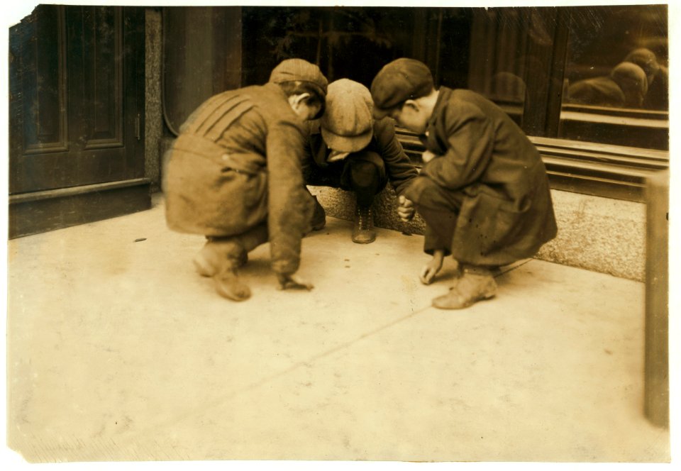 Mill boys pitching pennies on the Main St. in the afternoon. One said he sweeps. One said 'I was workin' but got canned 'cause I was not fast enough.' The other was 'jest hangin' around.' LOC cph.3b33406