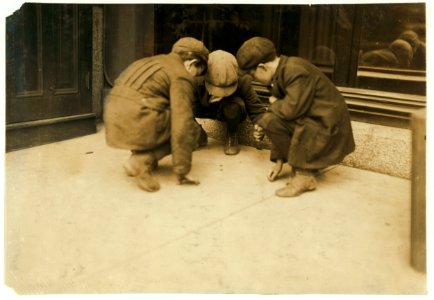 Mill boys pitching pennies on the Main St. in the afternoon. One said he sweeps. One said 'I was workin' but got canned 'cause I was not fast enough.' The other was 'jest hangin' around.' LOC cph.3b33406