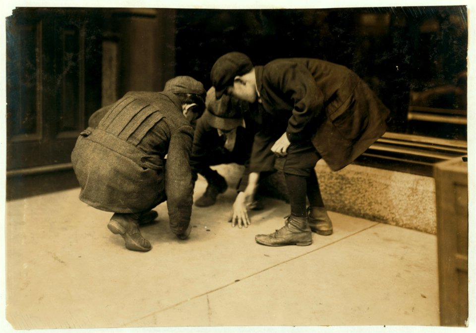 Mill boys pitching pennies on the Main St. in the afternoon. One said he sweeps. One said 'I was workin' but got canned 'cause I was not fast enough.' The other was 'jest hangin' around.' LOC nclc.03008