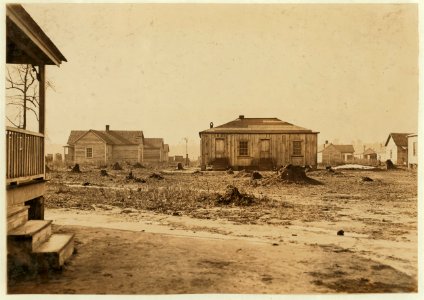 Mill School House (in middle) surrounded by mill houses. Maple Mill, Dillon, S.C. Small need here for large schoolhouse. Most of the children in mill. LOC nclc.01481
