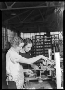 Millville, New Jersey - Glass bottles. Two girls stamping glass jars in the art room at T. C. Wheaton Company. This... - NARA - 518633