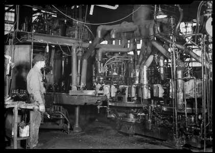 Millville, New Jersey - Glass bottles. (Man looking at machine.) - NARA - 518668